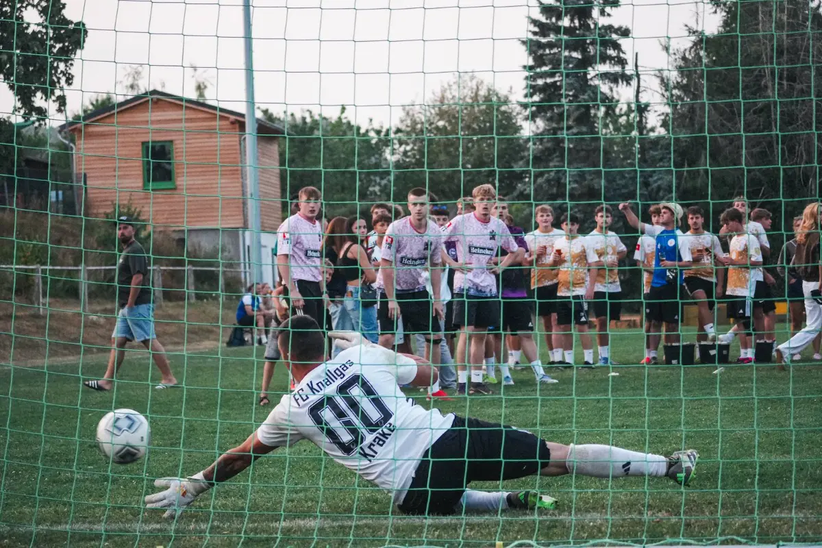 Ein Torwart hechtet nach dem Ball, das Tor bleibt leer