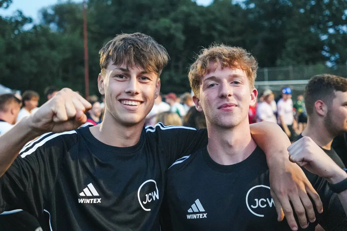 Zwei Spieler in schwarzen Trikots, den Arm um die Schulter gelegt