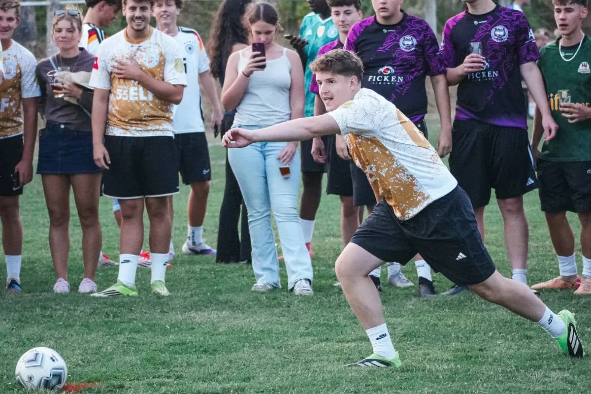 Ein Spieler holt zum Schuss aus, Zuschauer im Hintergrund