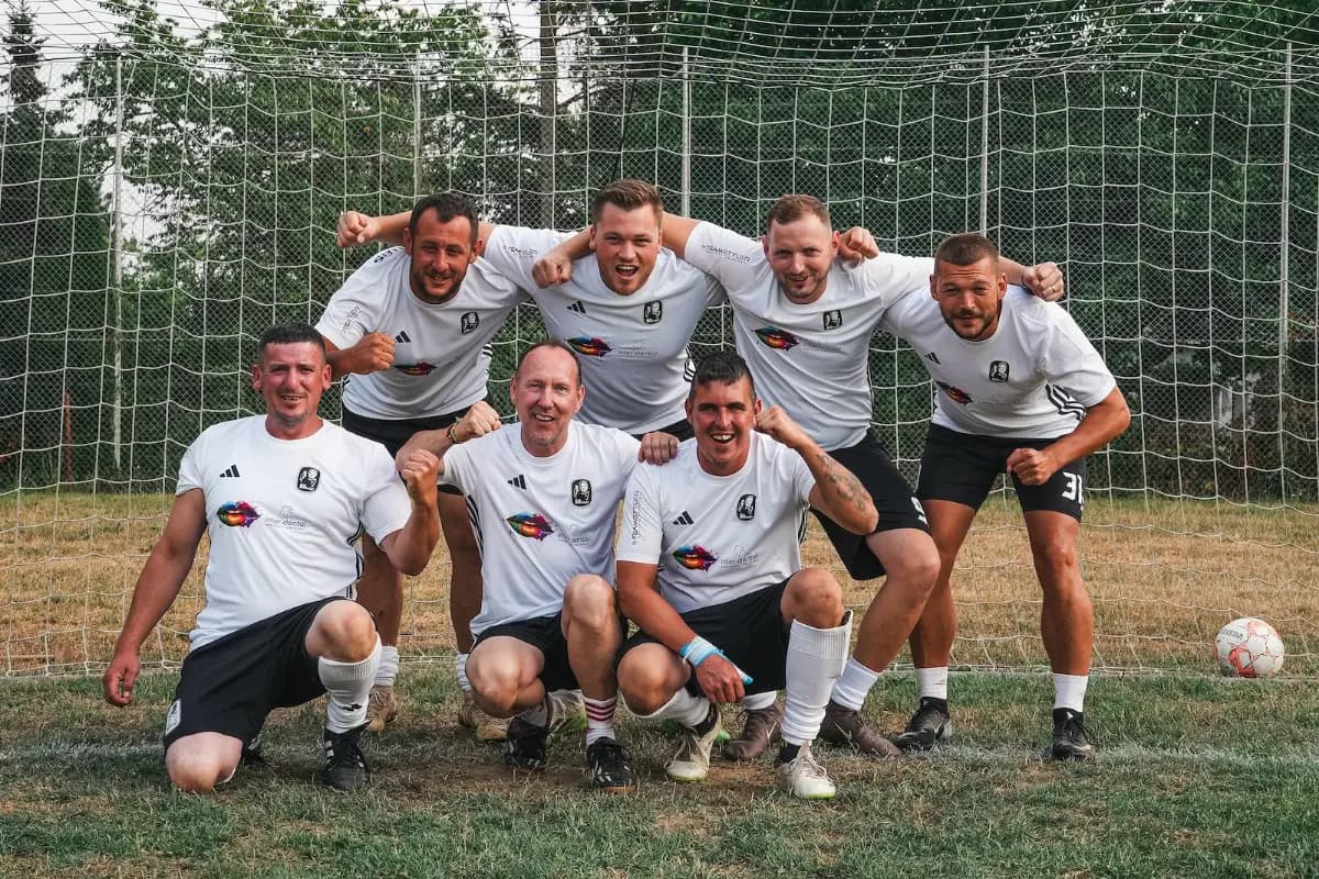 Ein Team in weißen Trikots stellt sich zum Bild auf