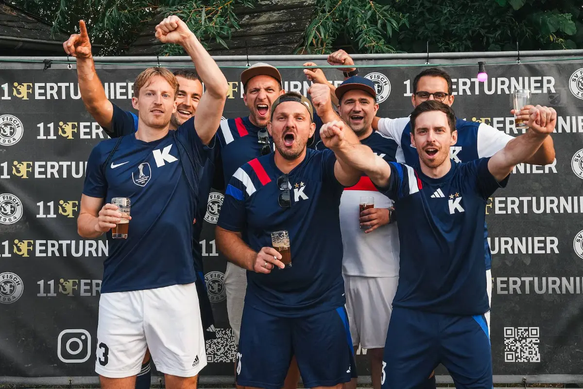 Ein Team in dunkelblauen Trikots vor der Turnierwand