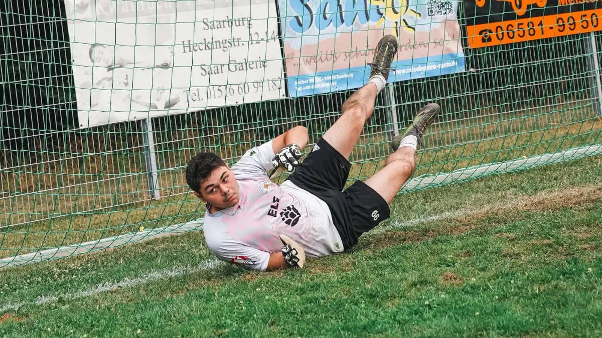 Ein Torwart streckt sich waagerecht nach dem Ball