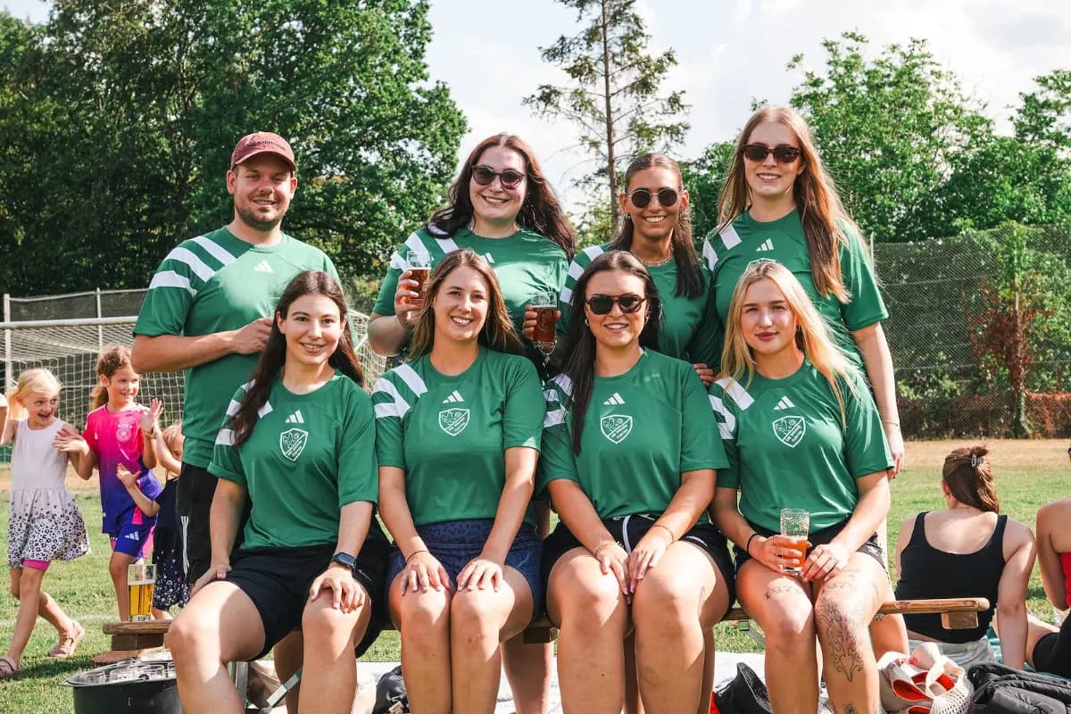 Ein Team in grünen Trikots stellt sich zum Bild