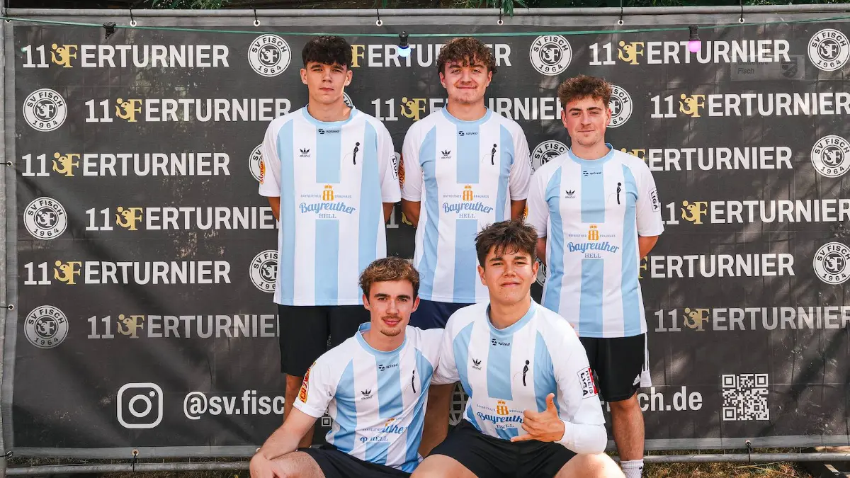 Ein Team in Weiß und Hellblau vor der Turnierwand