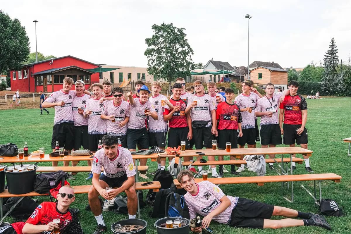 Ein Team in roten Trikots stellt sich vor dem Tor auf