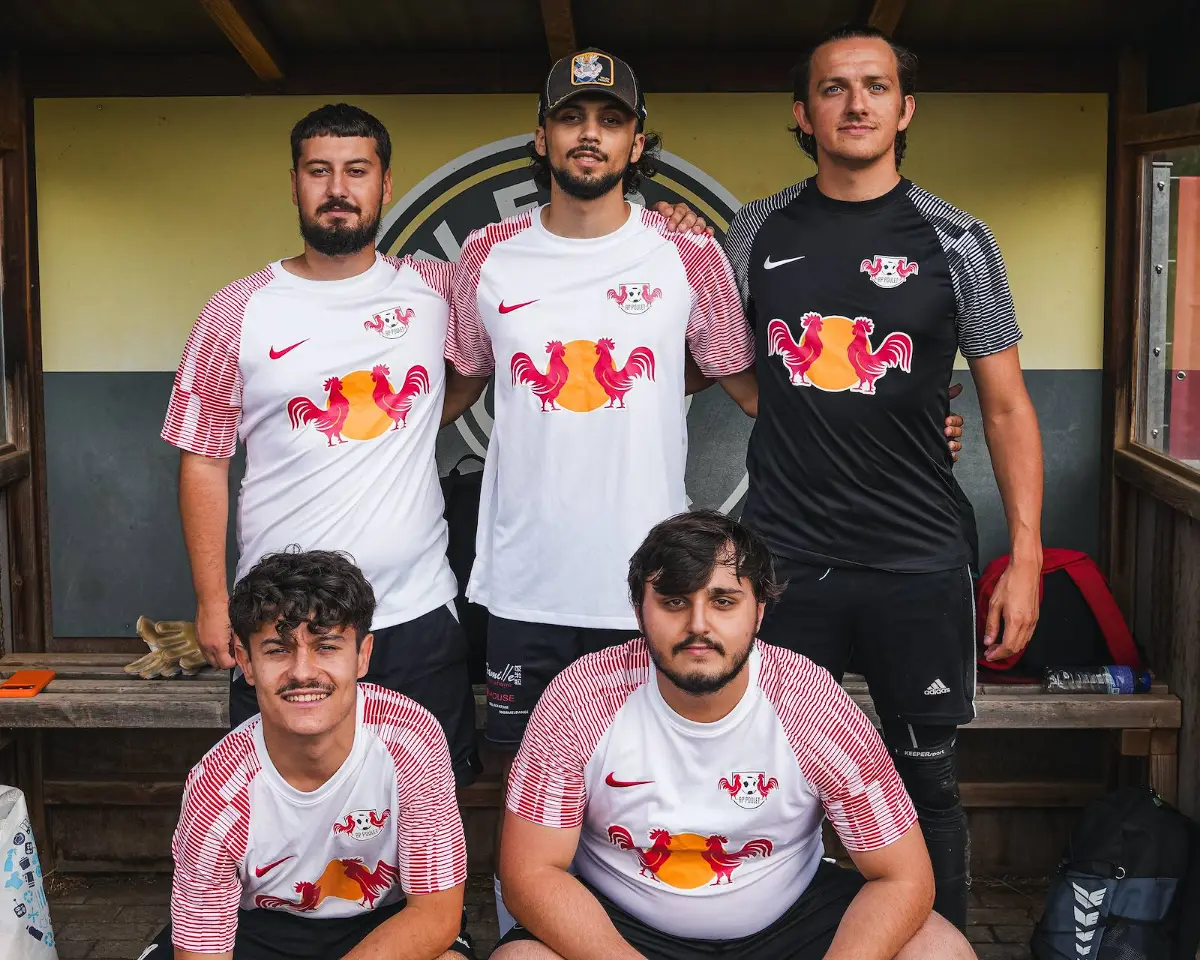 Drei Spieler in weißen und roten Trikots nach dem Spiel