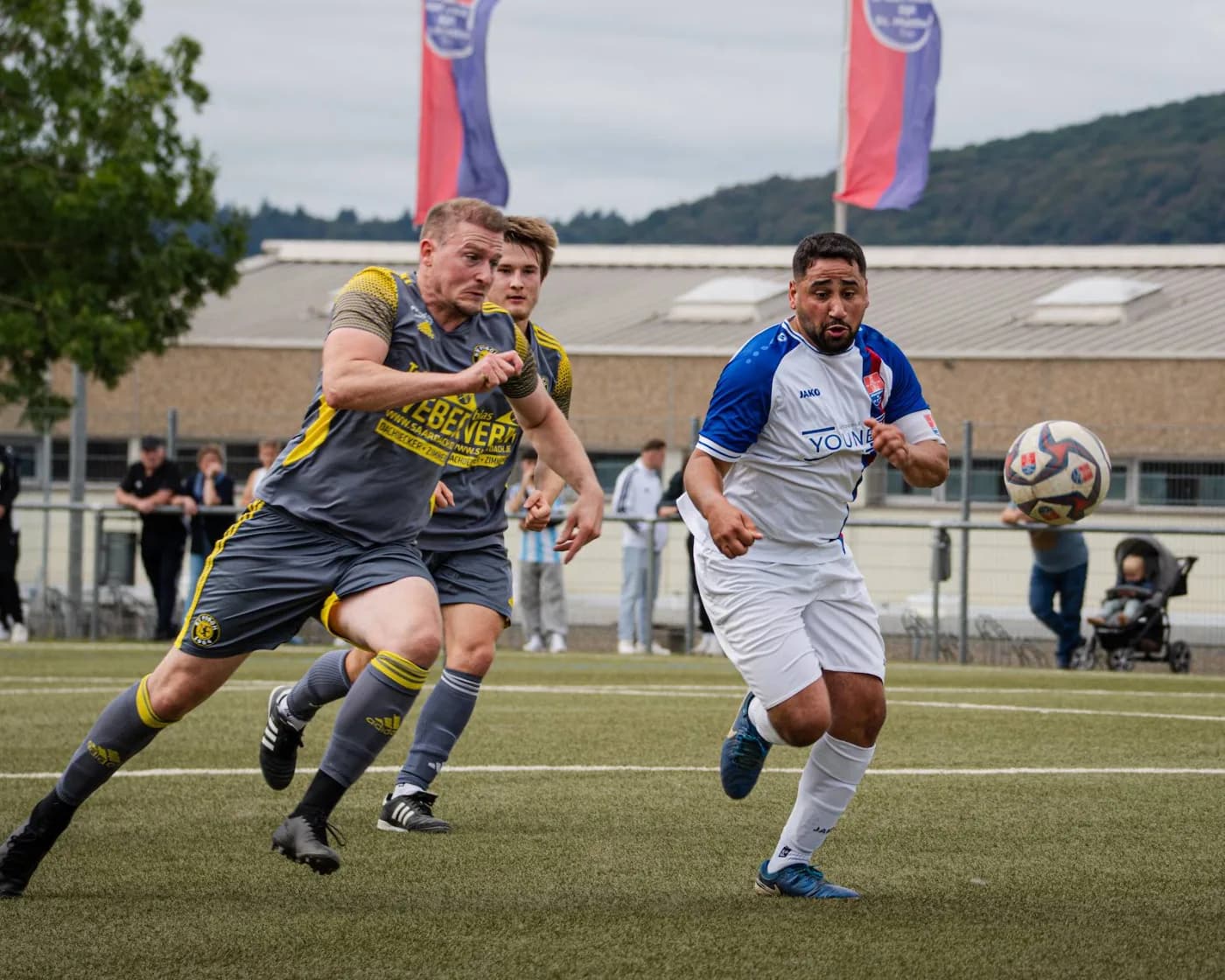 Zwei Spieler laufen Schulter an Schulter dem Ball hinterher
