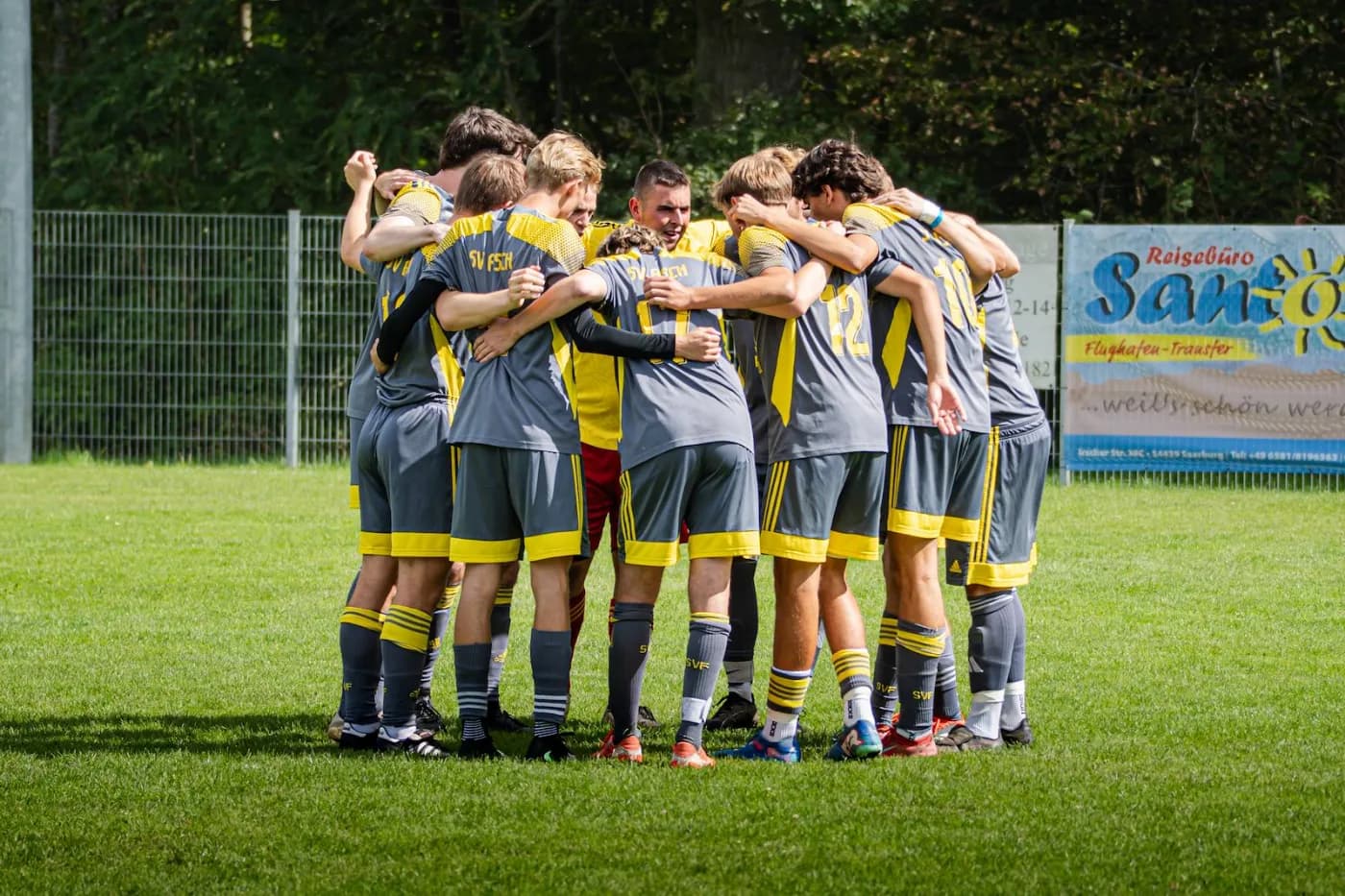 Die Mannschaft steht vor dem Anpfiff im Kreis, die Arme auf den Schultern der Nebenleute