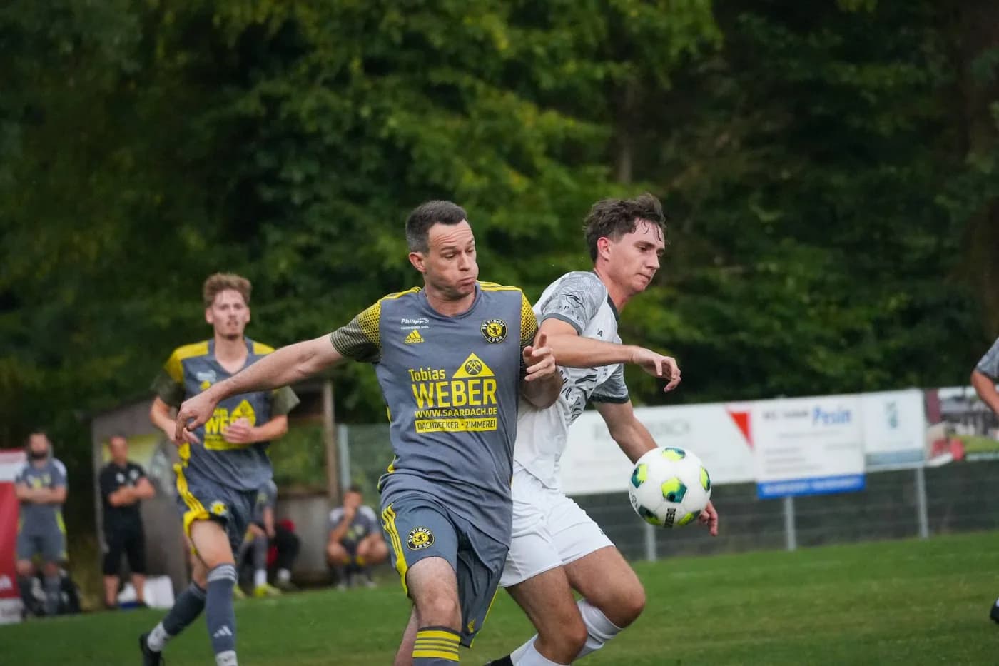 Zwei Spieler laufen eng nebeneinander dem Ball nach