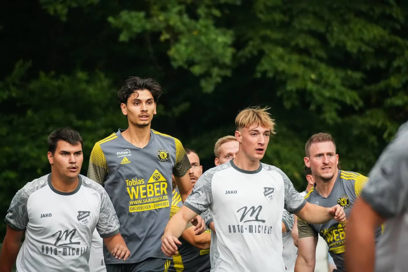 Mehrere Spieler stehen dicht beieinander und warten auf den Ball
