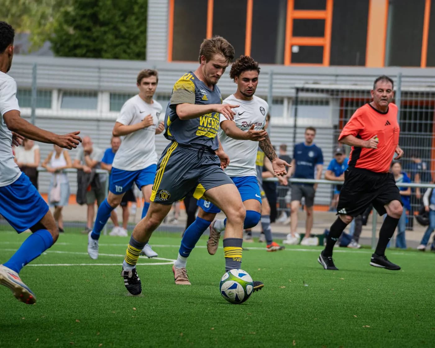 Ein Spieler führt den Ball durch mehrere Gegenspieler