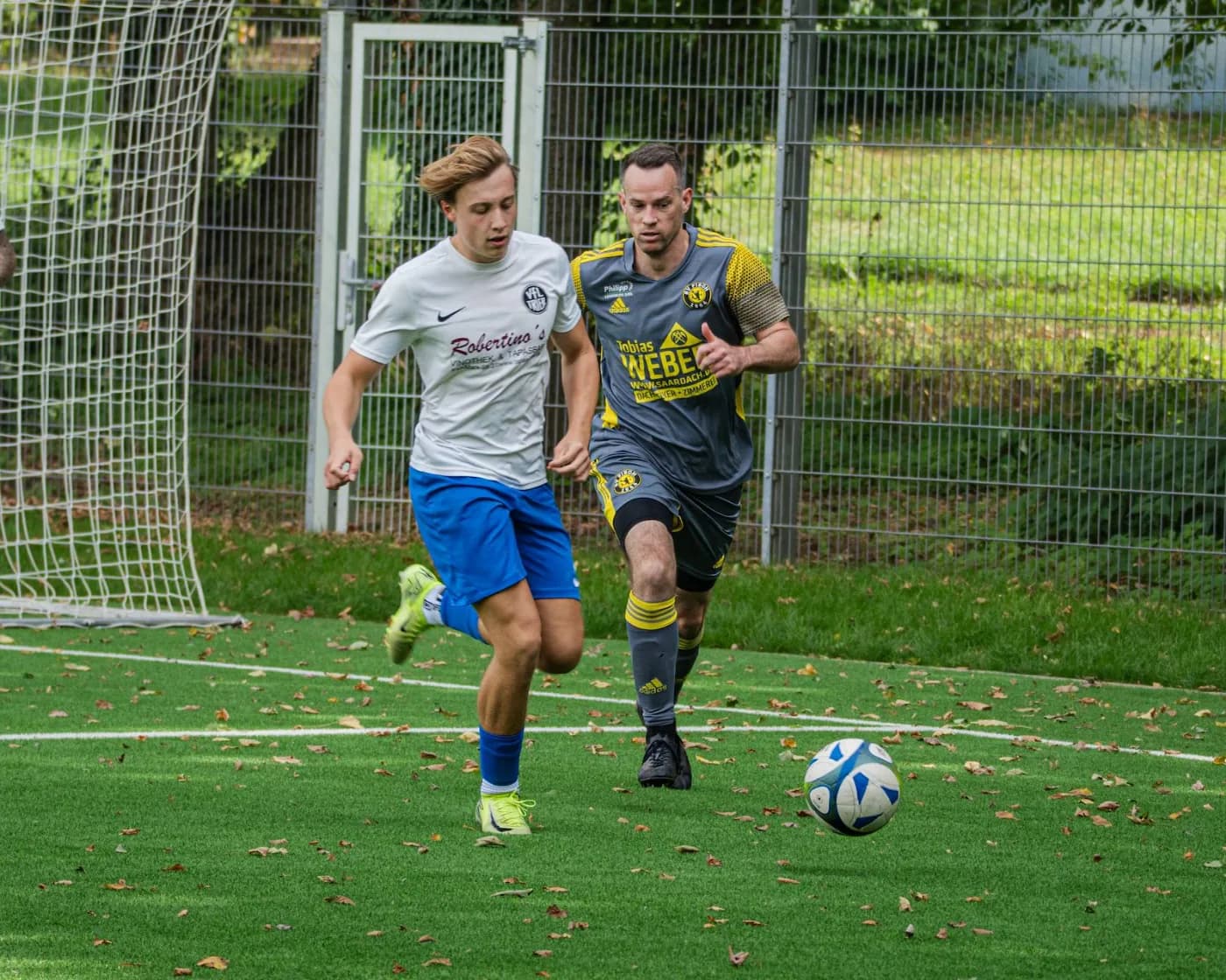 Zwei Spieler laufen mit dem Ball nebeneinander her